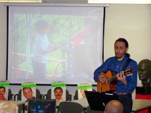 Daniel Rodríguez , argentinischer Sänger, Liedermacher und Gitarrist vor der Dia-Wand und den für die MAIMI 5 reserviert gehaltenen Stühlen