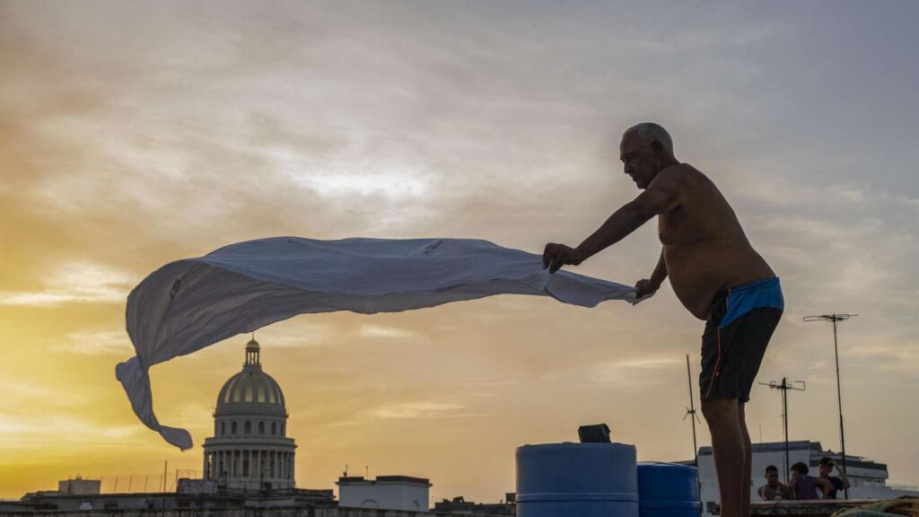 Schlaflos in Havanna: keine Klimaanlage ohne Strom 1 43827987 alexis mijan glaettet bei sonnenuntergang am 12 august 2026 in der altstadt von havanna die laken eines provisorischen bettes auf dem dach eines 3fwausvlpy7a8591154546542162783